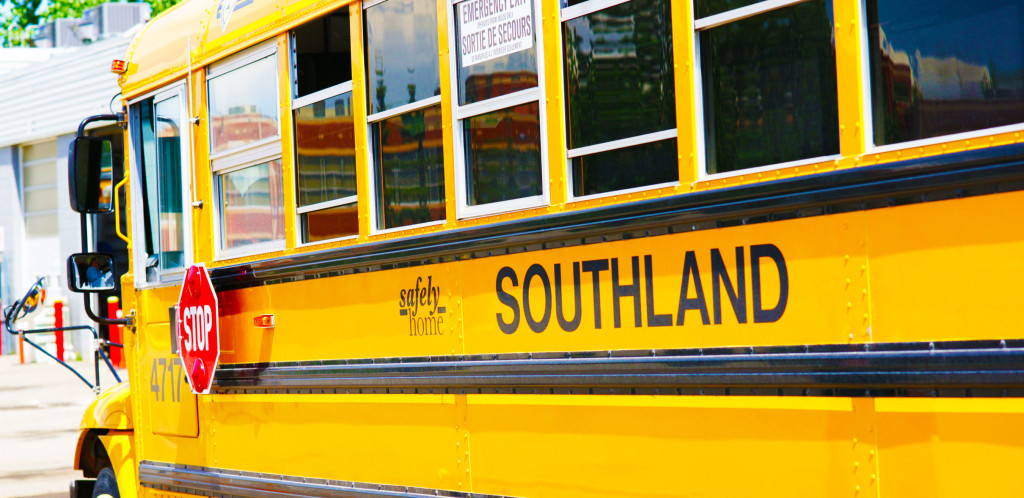Photo of the side of a yellow bus. Reads: Safely home and Southland